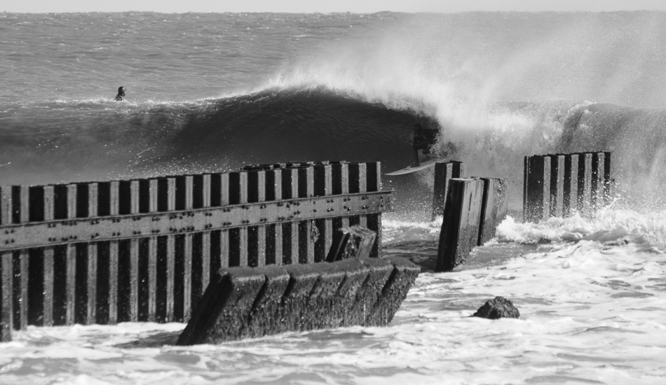 Winter surf here doesn\'t bode well for photographers. The light is weird... the water is a dirty chocolate brown.... But, the waves are pumping. The lack of green water sometimes requires black and white, but Florida charger Mark Dawson has relocated to the Outer Banks for the barrels, not the water color.